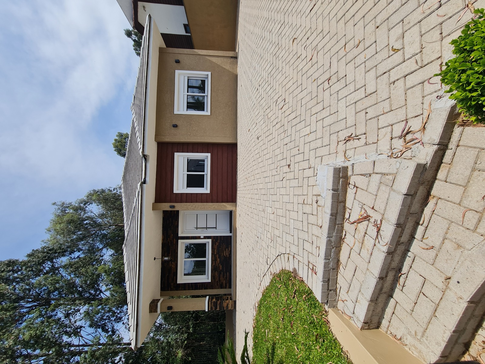Fachada com pedra e pátio pavimentado